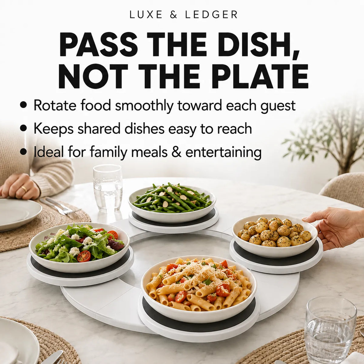 A white round serving platter with four bowls of food on a dining table, with a hand reaching for one bowl. Large text at the top reads 'PASS THE DISH, NOT THE PLATE' with bullet points describing rotation, shared dish accessibility, and family/entertaining use.