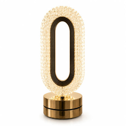 A modern oval-shaped table lamp with a textured, warm glowing crystal-like body, a black inner frame, and a polished gold metallic base, shown on a solid white background.