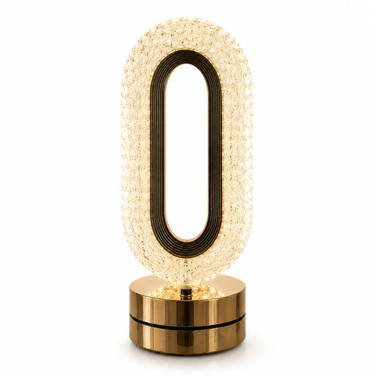 A modern oval-shaped table lamp with a textured, warm glowing crystal-like body, a black inner frame, and a polished gold metallic base, shown on a solid white background.