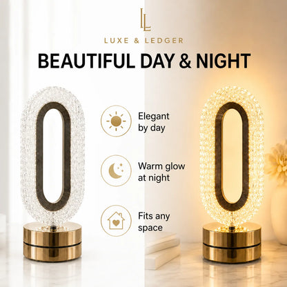 Luxe & Ledger oval table lamp shown in a split daytime and nighttime presentation. The lamp features a clear faceted crystal-like oval body with a dark metallic center and a polished gold base.