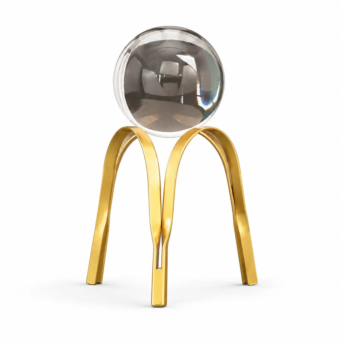 A modern decorative sculpture featuring a polished metallic gold double-arch stand supporting a large, reflective silver glass sphere, set against a seamless white background.