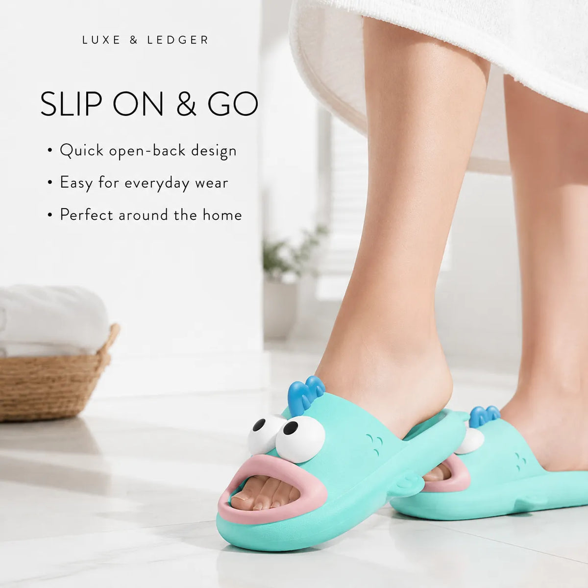 A person wearing a turquoise cartoon fish slip-on sludge with a pink mouth and white eyes, standing on a white tiled floor. The image includes text overlays describing the slip-on design and features, with a white towel at the top and a basket in the background.