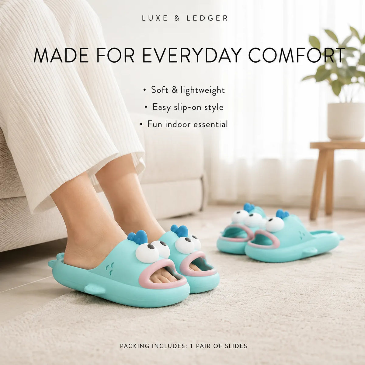 A person wearing light blue shark-themed slip-on slippers in a bright indoor room. The slippers have a cartoon shark face with white eyes, pink lips, and small blue fins.
