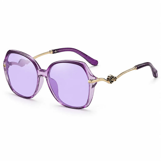 Oversized square sunglasses with translucent purple frames and purple-tinted lenses, accented by gold metal temples and a decorative emblem near the hinge.