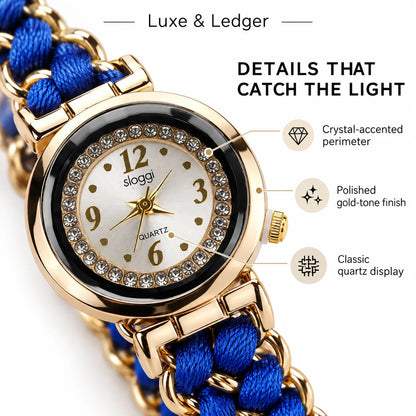 A close-up product shot of a Luxe & Ledger women's watch with a gold-tone case, crystal-accented bezel, white dial, and a blue braided strap. Callout lines and text highlight details such as the crystal-accented perimeter, polished gold-tone finish, and classic quartz display.