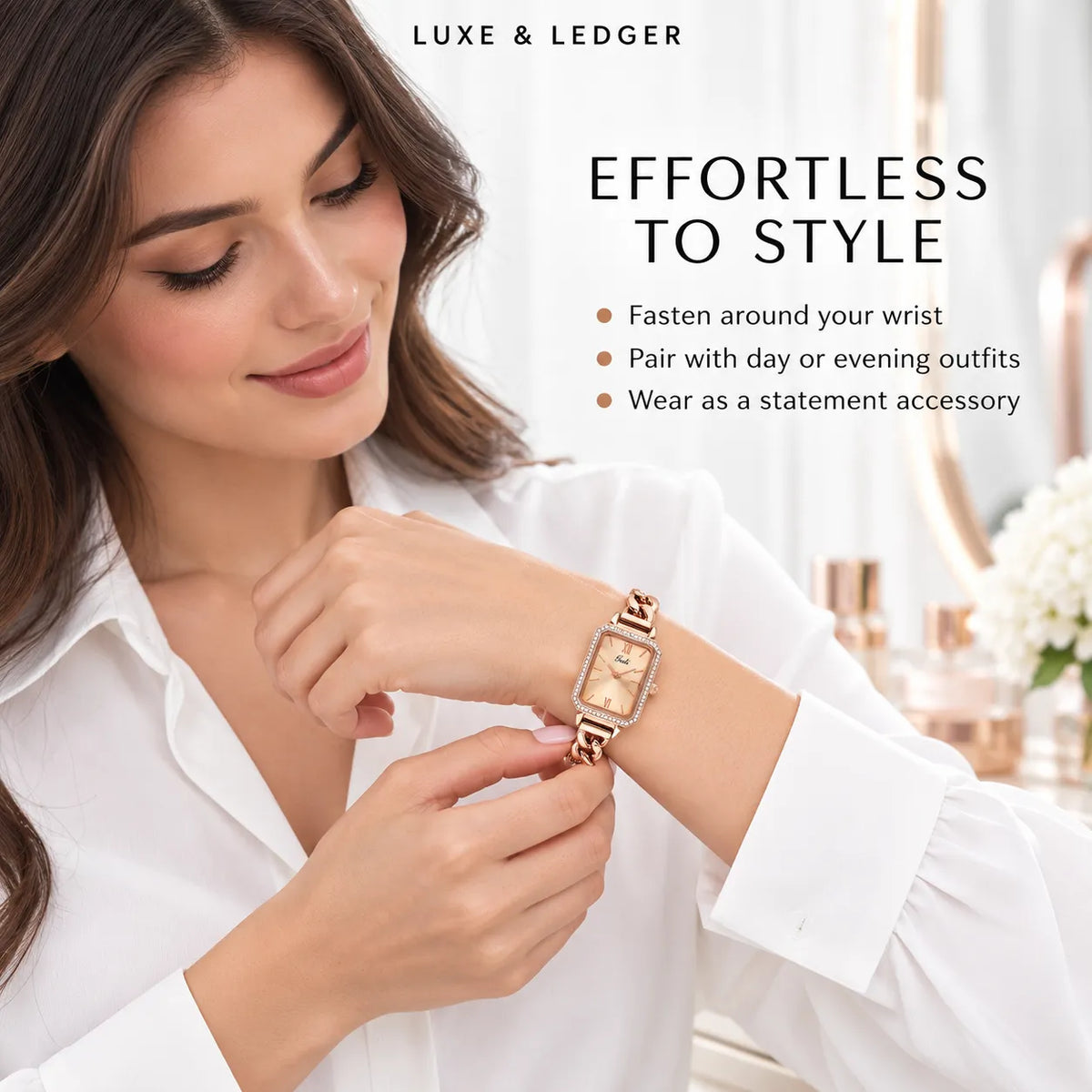 A woman in a white blouse adjusts a rose gold-tone Luxe & Ledger watch on her wrist. The watch has a rectangular gold-toned dial and a matching rose gold link bracelet.