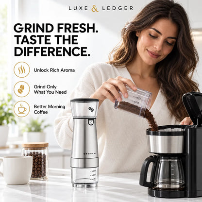 A woman in a white sweater pours ground coffee from a clear measuring cup into a black and stainless steel coffee maker on a bright kitchen counter. A matching stainless steel coffee grinder stands beside it, with marketing text and icons on the left reading 'GRIND FRESH.