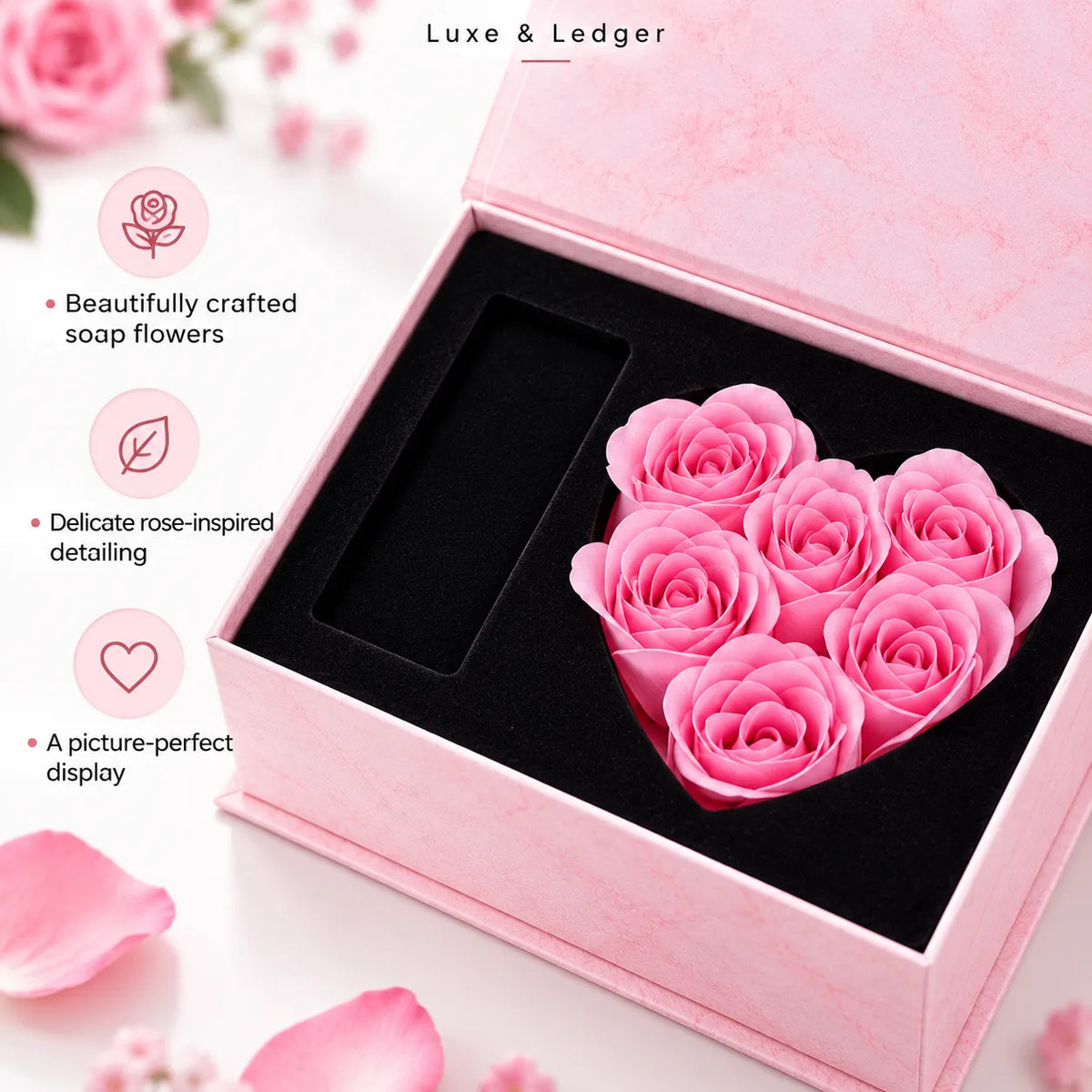 A pink heart-shaped preserved soap flower arrangement displayed inside an open pink gift box with a black insert. The image includes marketing text on the left highlighting beautifully crafted soap flowers, delicate rose-inspired detailing, and a picture-perfect display.