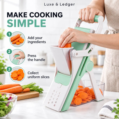 A manual vegetable slicer shown in use on a kitchen counter, with a person's hands pushing the handle. The slicer is white and mint green, slicing carrots into pieces.