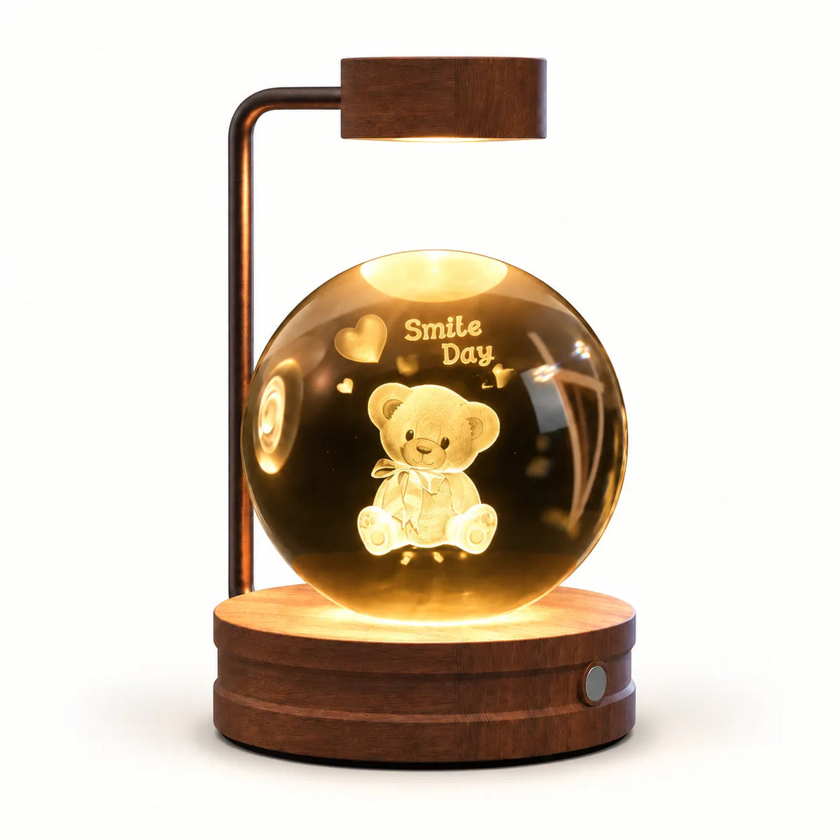 A wooden table lamp with a glowing clear glass globe containing a teddy bear and the words 'Smile Day,' mounted on a round wooden base with a curved wooden arm and rectangular lamp head.