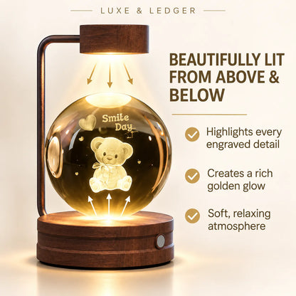 A wooden LED night light lamp with a spherical glass shade featuring an engraved teddy bear and the words 'Smile Day'. The lamp is shown lit from above and below, casting a warm golden glow.