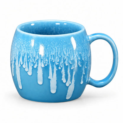 A bright blue ceramic mug with a white dripping glaze design, shown on a clean white background.