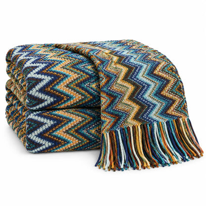 A folded woven throw blanket with a multicolor chevron pattern and fringe, shown on a clean white background.