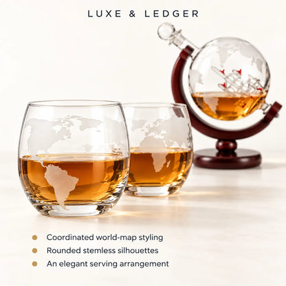Two clear stemless whiskey glasses with etched world-map designs filled with amber liquor, shown beside a globe-shaped decanter on a stand. The text 'LUXE & LEDGER' appears at the top, and feature callouts appear at the bottom.