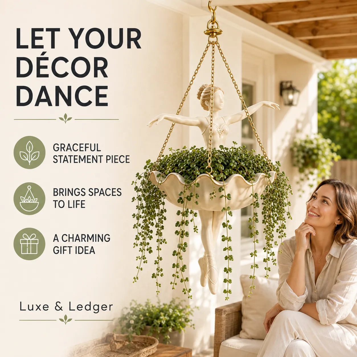 A hanging garden planter featuring a classical-style cherub statue in a cream-colored shell-shaped planter, with trailing green ivy. The planter hangs from a gold-toned chain on a porch, next to a woman sitting on a bench.