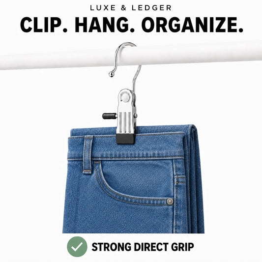 A silver metal pants clip hanging from a white rod, holding a pair of blue jeans. Text at the top reads 'LUXE & LEDGER CLIP.