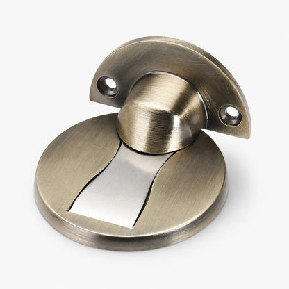 A round door stopper with a brushed brass finish and a central silver metal strip, shown on a light gray background.