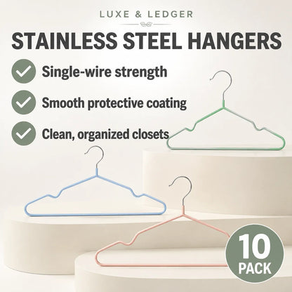 Promotional graphic for a 10-pack of Luxe & Ledger stainless steel hangers. The image features three minimalist wire hangers in light blue, light green, and light pink, displayed on white cylindrical pedestals.