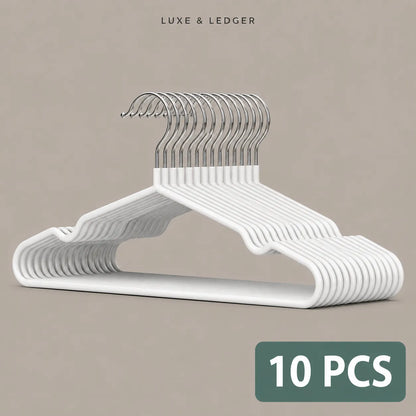 Ten white plastic hangers with silver metal hooks, stacked and displayed on a neutral beige background. The brand name 'LUXE & LEDGER' is printed at the top, and a green label at the bottom right reads '10 PCS'.