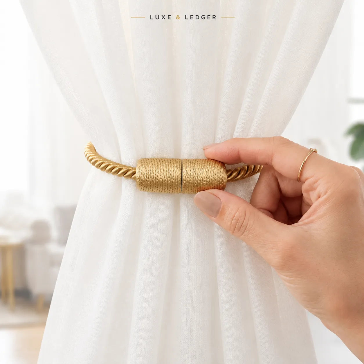 A close-up of a hand holding a gold rope-style curtain tieback against a white sheer curtain, with the brand name 'LUXE & LEDGER' at the top.