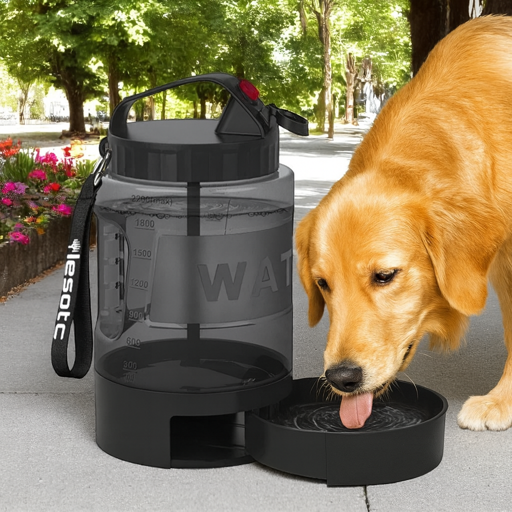 Black portable pet water bottle with a dog drinking from it outdoors.