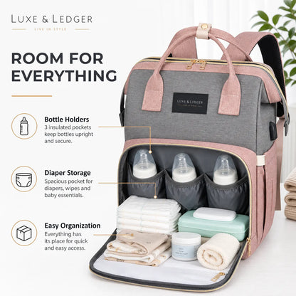 Diaper bag with bottle holders and storage compartments on a white background, featuring Luxe & Ledger branding.