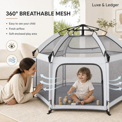Child playing inside a soft enclosed play area with breathable mesh, surrounded by a woman.