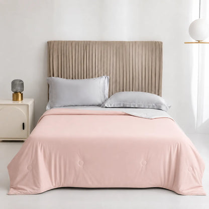 Bed with pink comforter and beige headboard in a minimalistic room