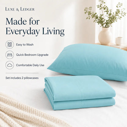Light blue bedding set with pillows and folded sheet on a bed, featuring Luxe & Ledger branding.