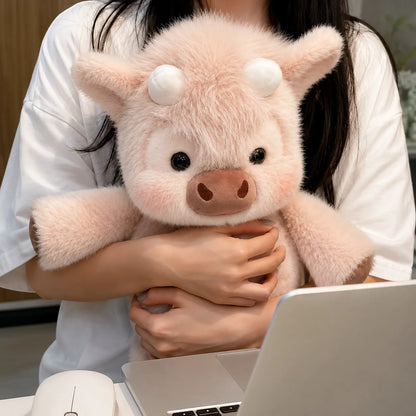 Person holding a pink plush pig toy in front of a laptop.