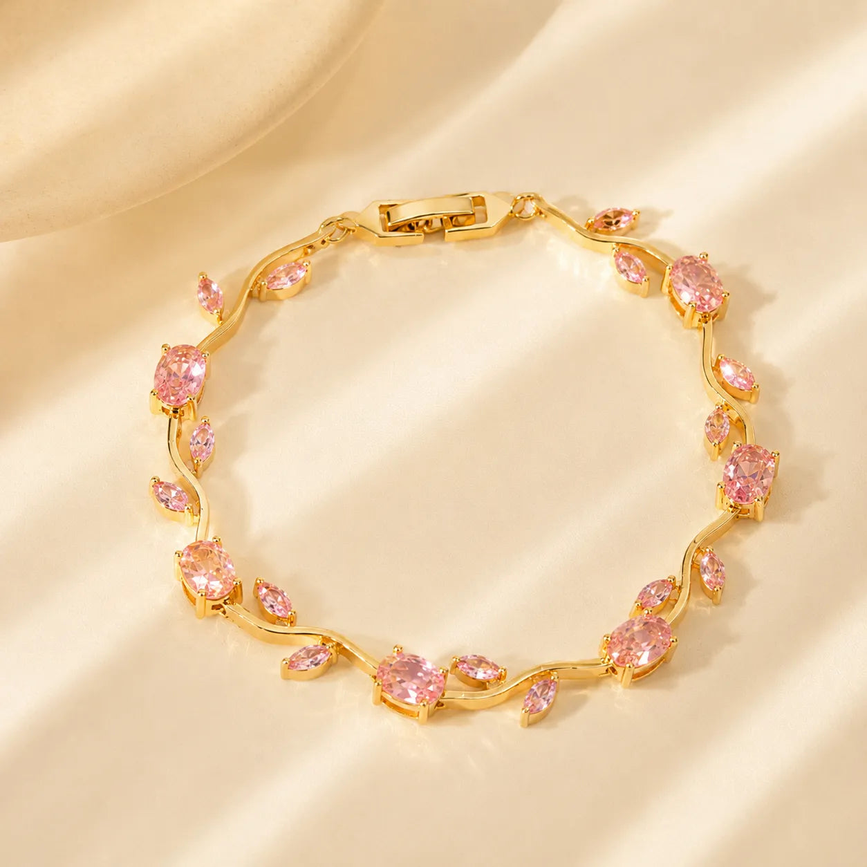 Gold bracelet with pink gemstones on a beige background