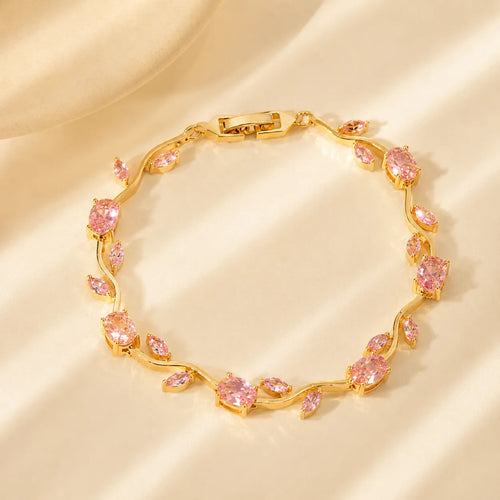 Gold bracelet with pink gemstones on a beige background
