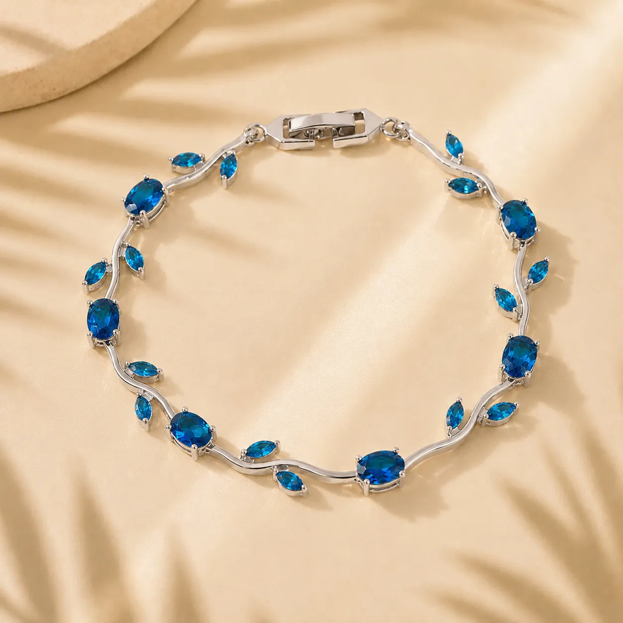 Silver bracelet with blue gemstones on a beige background