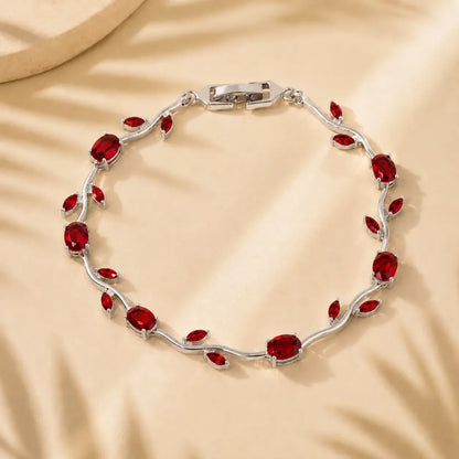 Silver bracelet with red gemstones on a beige background