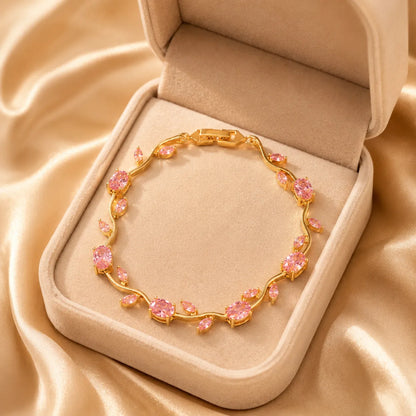 Gold bracelet with pink stones in a jewelry box on beige fabric