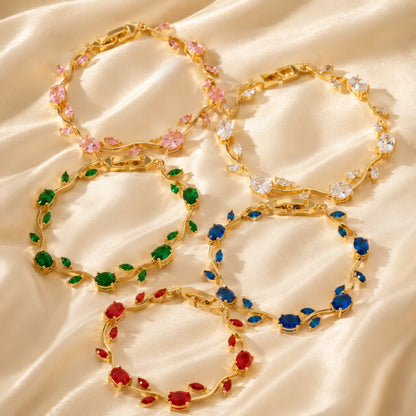 Gold bracelets with colorful gemstones on a beige fabric background