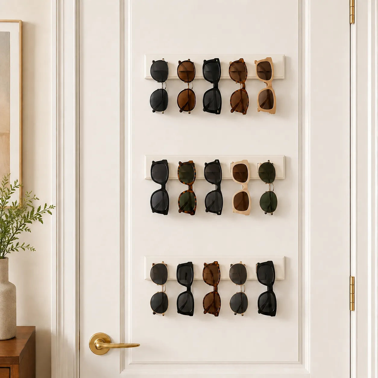 Wall-mounted sunglasses holder with multiple pairs of sunglasses on a white door.