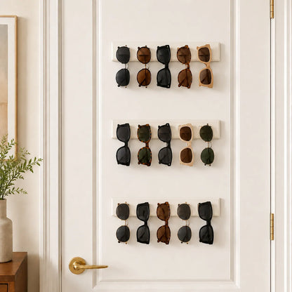 Wall-mounted sunglasses holder with multiple pairs of sunglasses on a white door.