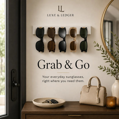 Wall-mounted sunglasses holder with sunglasses, handbag, and decor items on a table.