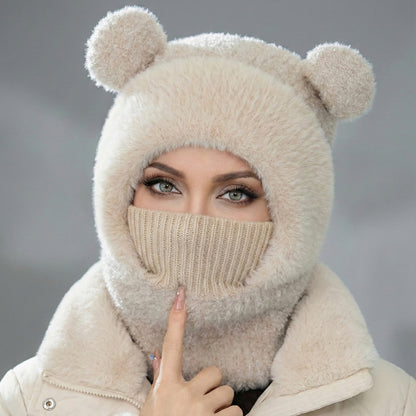 Person wearing a beige knitted balaclava with bear ears against a gray background