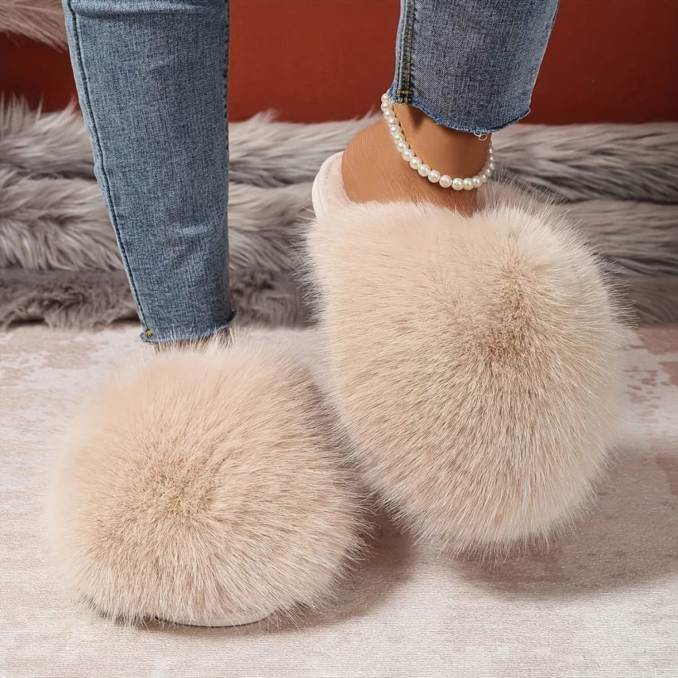 Beige fluffy slippers worn with jeans on a soft surface