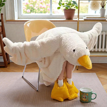 Person wearing large duck-shaped slippers in a cozy room with a mug and plants.