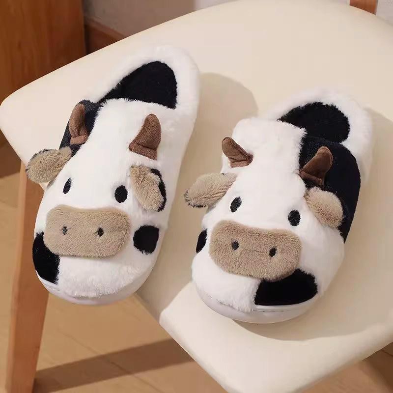 Pair of cow-themed slippers on a chair