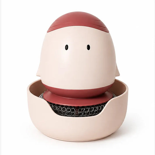 A ceramic dishwashing sponge holder shaped like a stylized face, featuring a cream-colored body, a dusty red top and mouth, and a black mesh sponge resting in a shallow cream-colored base, set against a plain white background.