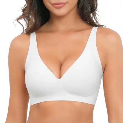 A woman wearing a white wireless bralette with a deep V-neckline and wide shoulder straps, shown from the chest up against a plain white background.