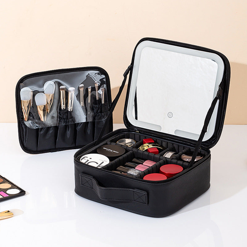 Black makeup travel case with open lid displaying various cosmetic items on a light background