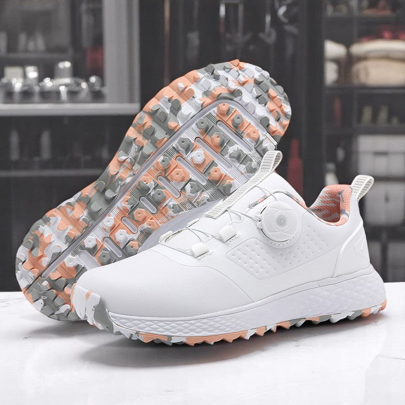 A pair of white golf shoes with a non-slip rubber sole, designed for all-terrain play on a green surface with golf balls and clubs in the background.