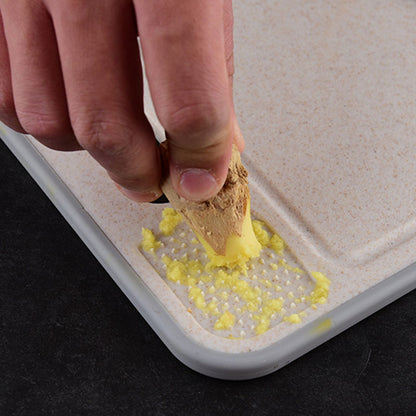 Hand using a yellow sponge to clean a white surface with a black background
