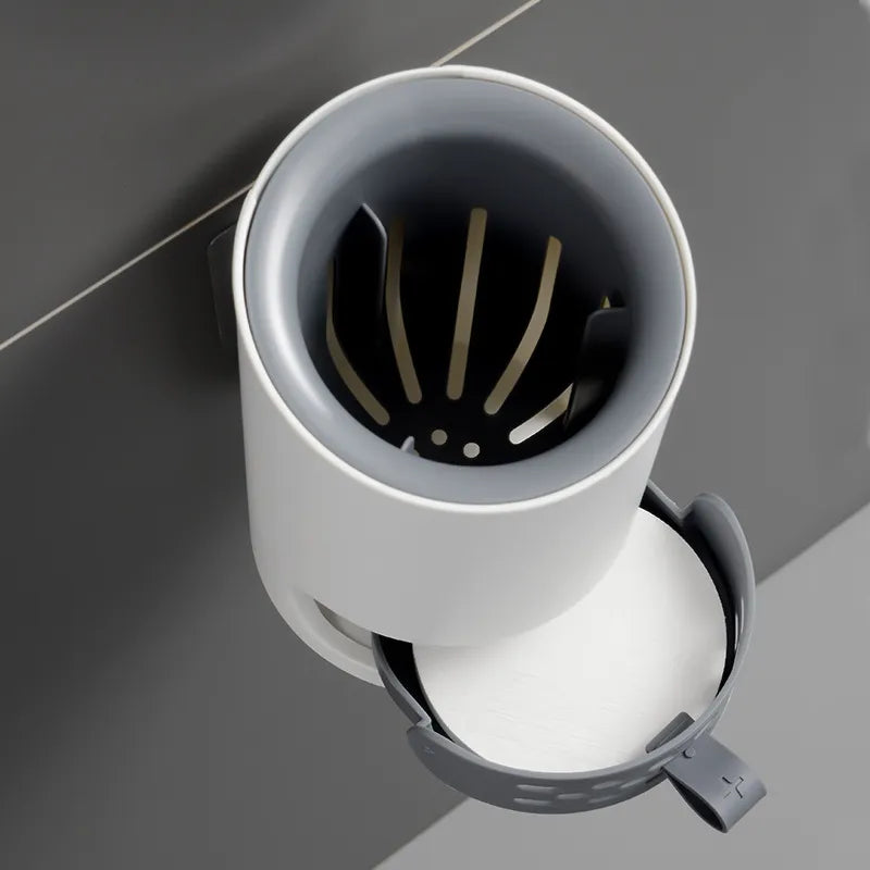 White sink drain with a black strainer on a gray tiled background