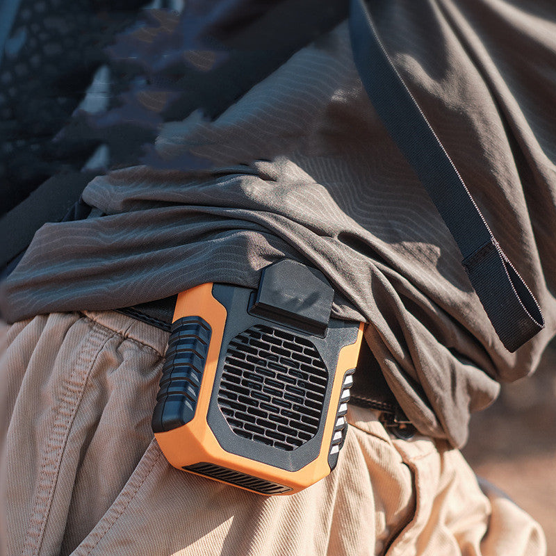 Portable fan attached to a person's belt with a blurred background